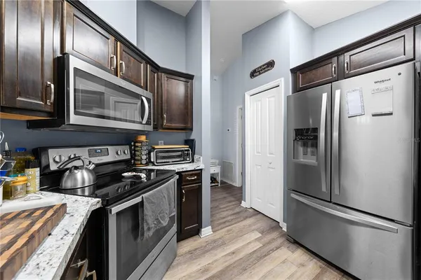 a kitchen with stainless steel appliances granite countertop a refrigerator and a stove top oven