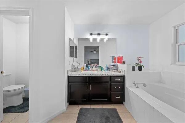 a spacious bathroom with a tub sink and mirror