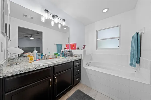a bathroom with a tub sink and mirror