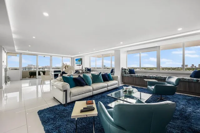 a living room with furniture and a view of kitchen