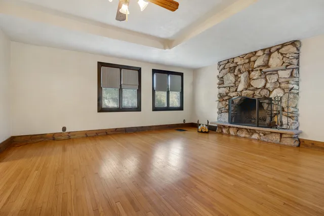 an empty room with wooden floor and fireplace