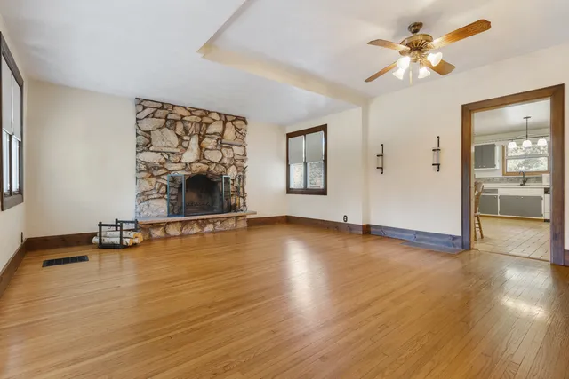 an empty room with wooden floor and a floor to ceiling window