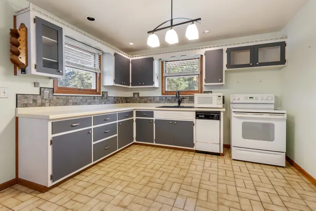 a kitchen with a stove sink and cabinets