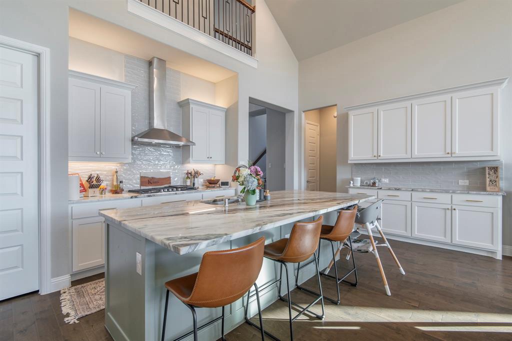 16650 Nightshade Road Frisco, TX 75033 - Photo 14 of 40 a kitchen with kitchen island granite countertop a table chairs stove and cabinets