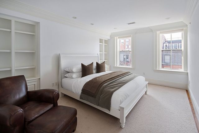 a bedroom with a bed couch and a window