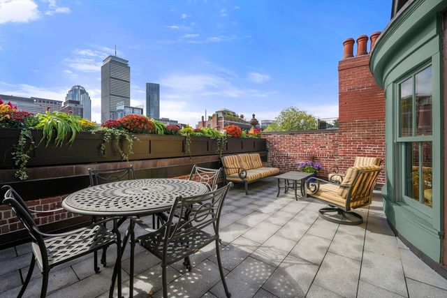 a view of a patio with a table and chairs next to a yard