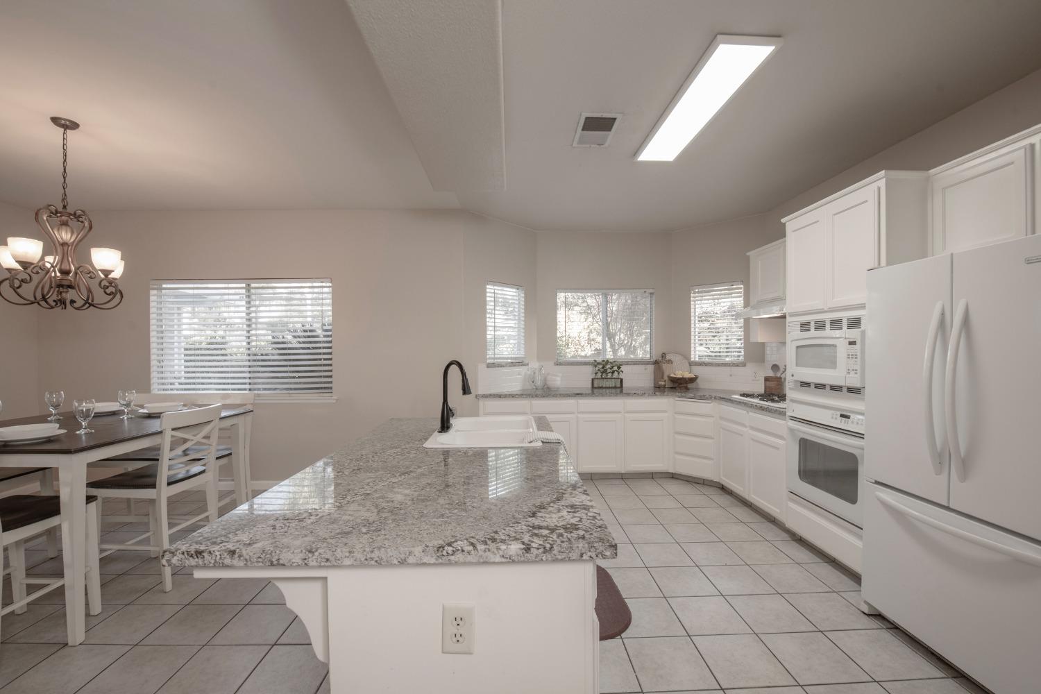 1847 Goshen Avenue Clovis, CA 93611 - Photo 7 of 39 a large white kitchen with cabinets