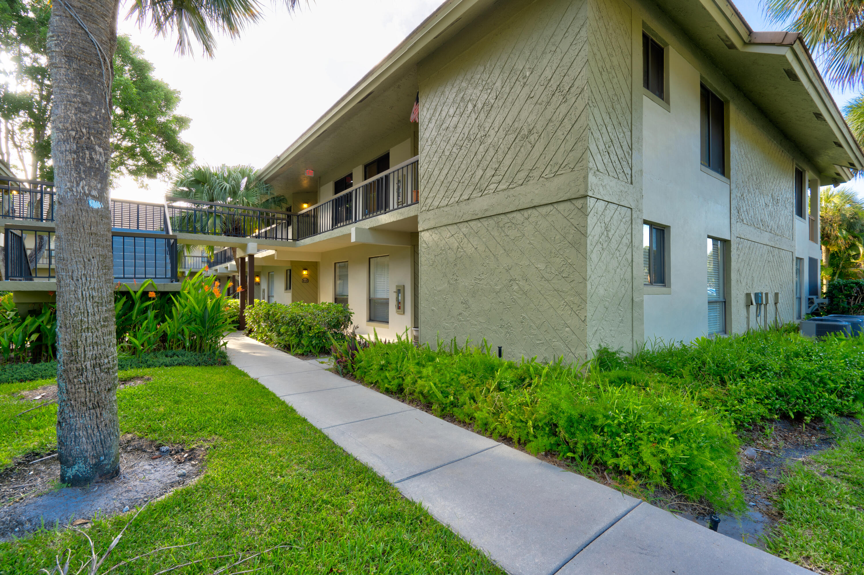 159 Northwest 70th Street, Unit 516 Boca Raton, FL 33487 - Photo 14 of 39 a backyard of a house with potted plants and large tree