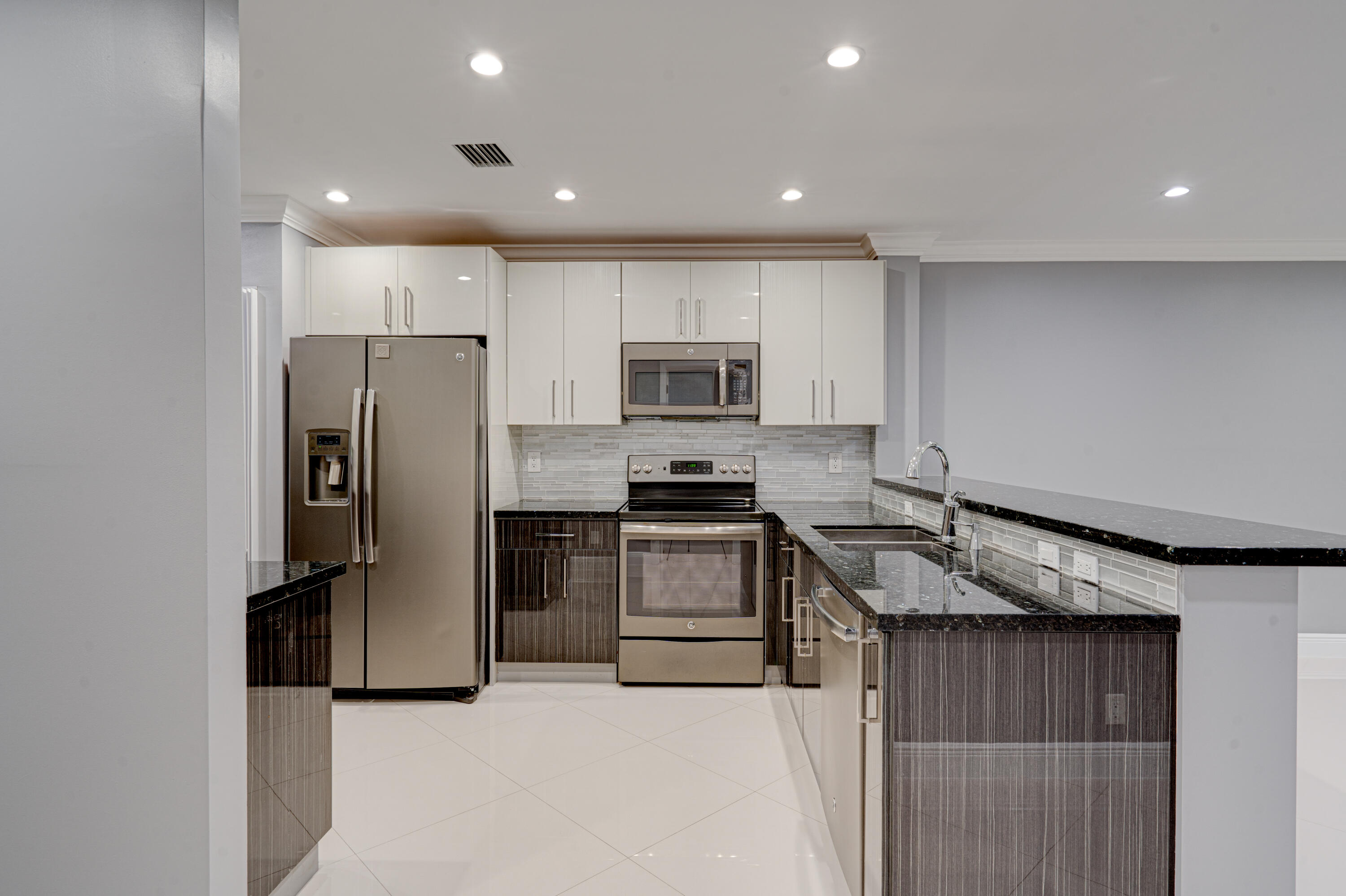 159 Northwest 70th Street, Unit 516 Boca Raton, FL 33487 - Photo 17 of 39 a kitchen with granite countertop a refrigerator and a stove top oven