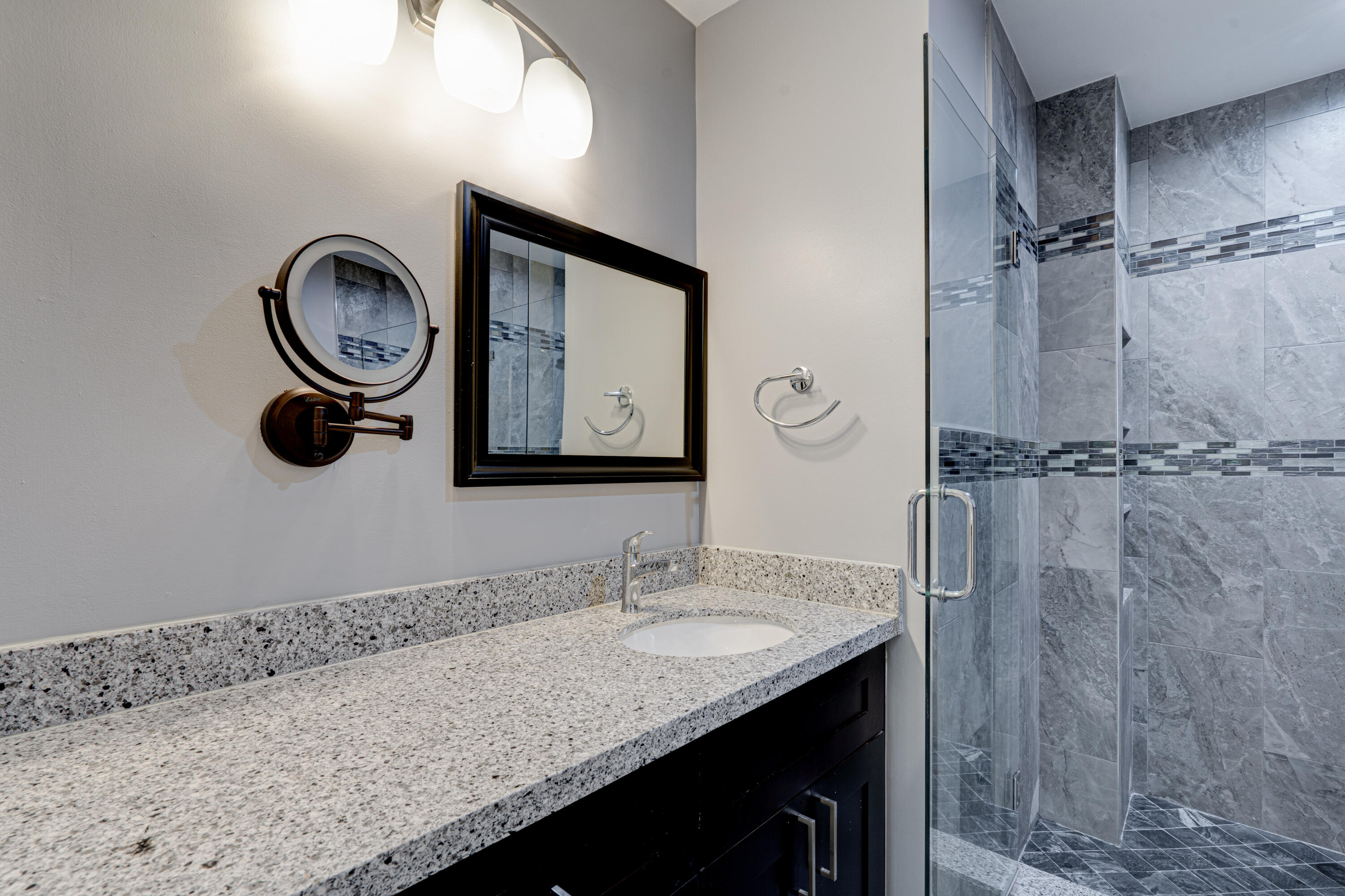 159 Northwest 70th Street, Unit 516 Boca Raton, FL 33487 - Photo 32 of 39 a bathroom with a granite countertop sink a mirror and a shower