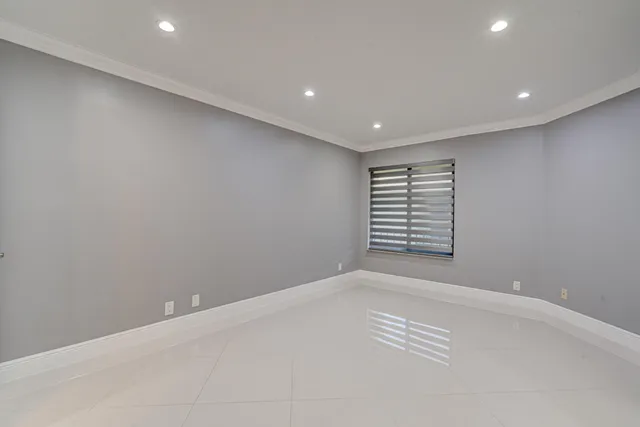 an empty room with closet and a kitchen