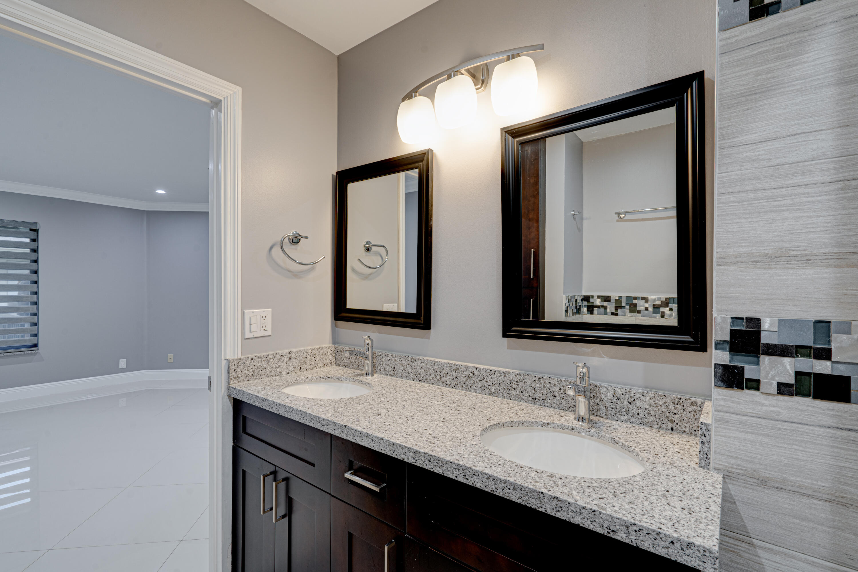 159 Northwest 70th Street, Unit 516 Boca Raton, FL 33487 - Photo 39 of 39 a bathroom with a granite countertop sink vanity and a mirror