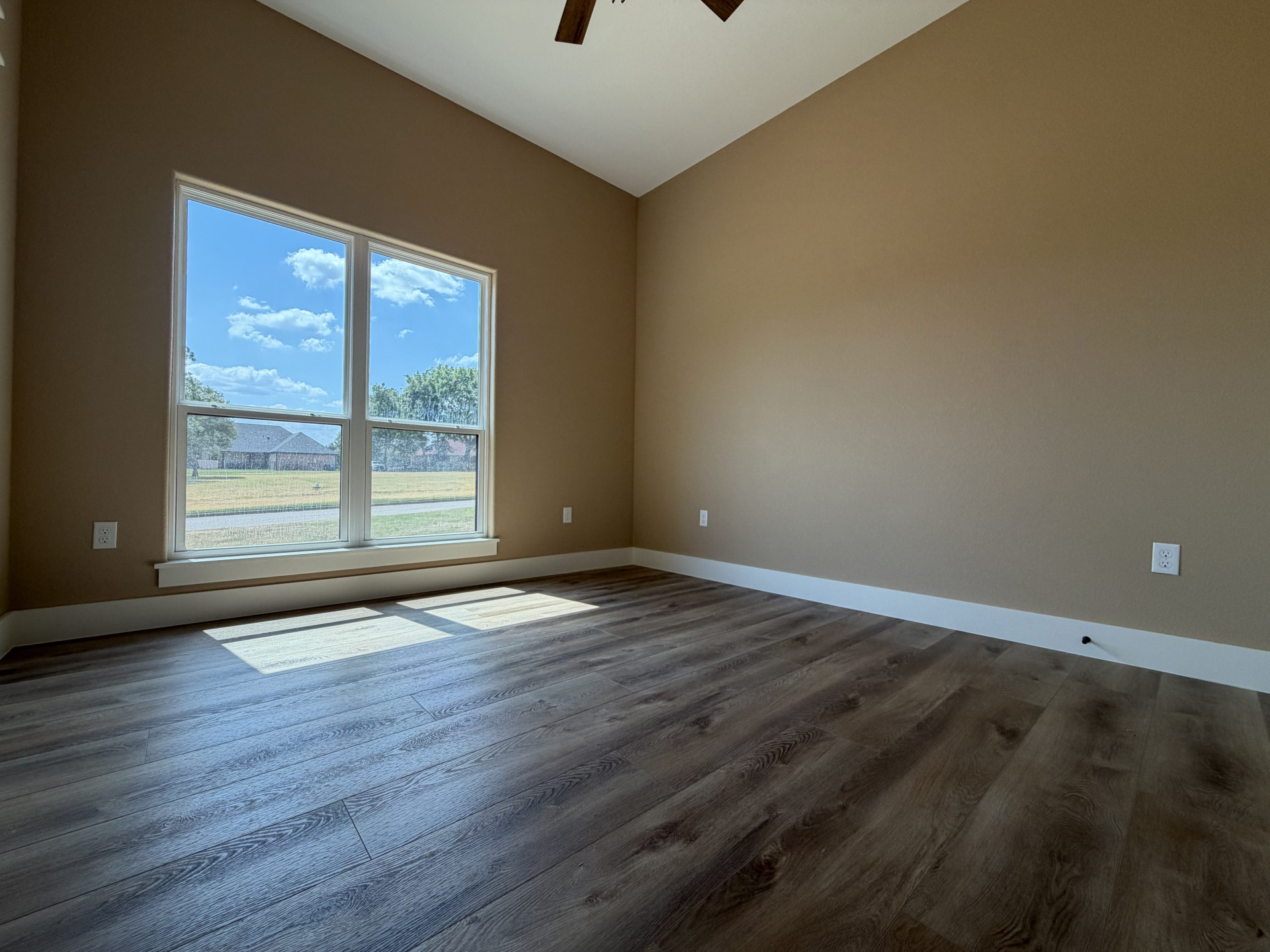 33 Wilderness Road North Calera, OK 74730 - Photo 28 of 39 Vaulted ceiling with a ceiling fan, wood-finish flooring, and a large window