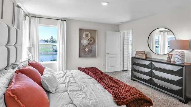 a bedroom with a bed a mirror and a window