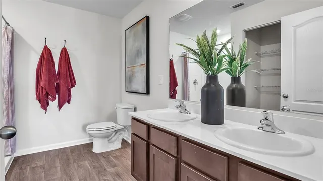 a bathroom with a toilet sink and mirror