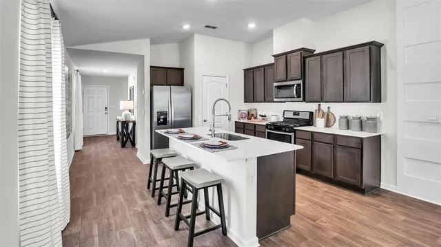 a kitchen with a sink a microwave a stove and refrigerator