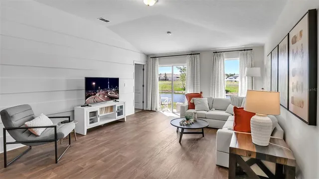 a living room with furniture and a flat screen tv with wooden floor