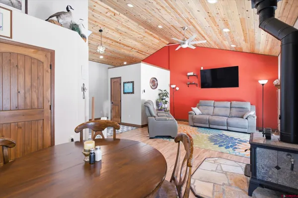 a living room with furniture a flat screen tv and floor to ceiling window