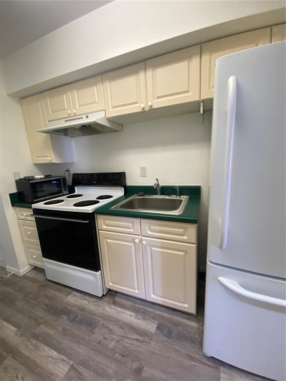 22302 Vick Street, Unit 112 Punta Gorda, FL 33980 - Photo 4 of 10 a kitchen with stainless steel appliances a stove and a refrigerator