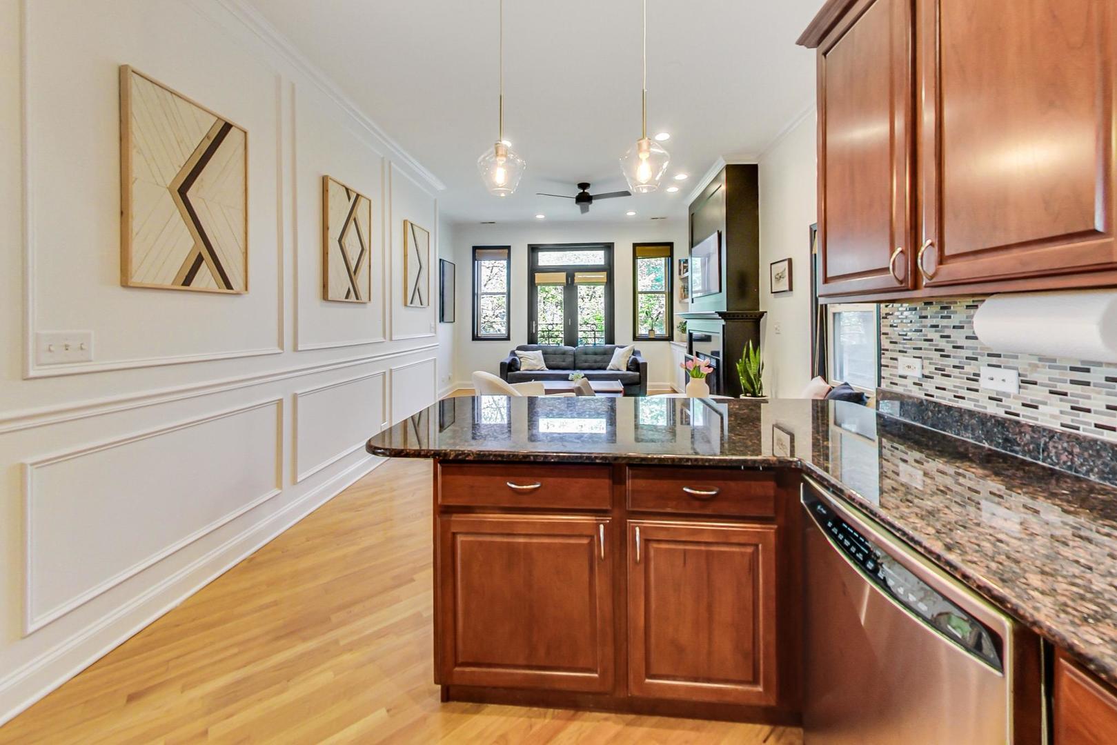 933 West Wolfram Street, Unit 2 Chicago, IL 60657 - Photo 11 of 24 a kitchen with stainless steel appliances granite countertop a sink and a wooden cabinets