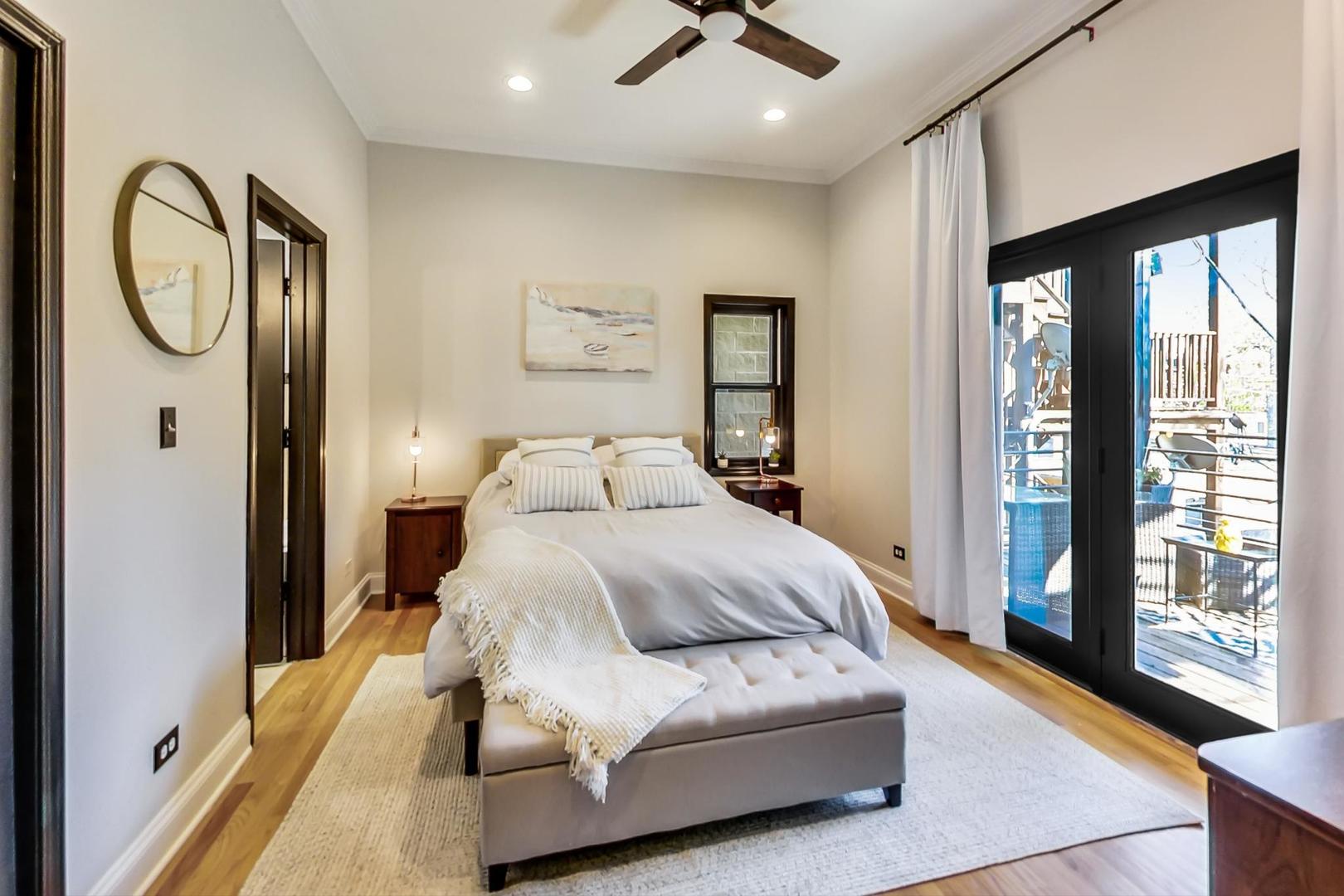 933 West Wolfram Street, Unit 2 Chicago, IL 60657 - Photo 12 of 24 a spacious bedroom with a bed a mirror and a large window