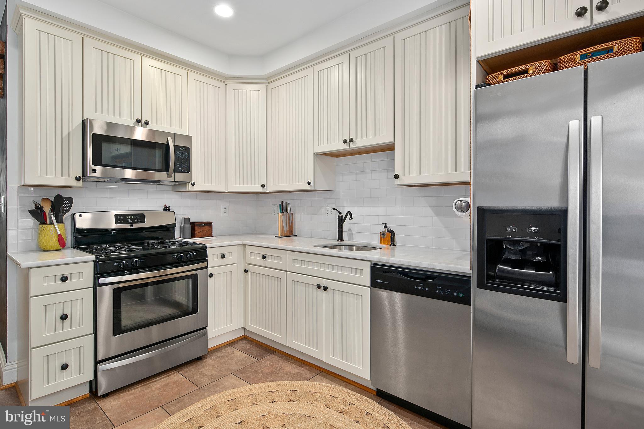 1437 G Street Northeast Washington, DC 20002 - Photo 11 of 24 a kitchen with stainless steel appliances granite countertop a stove a sink and a refrigerator