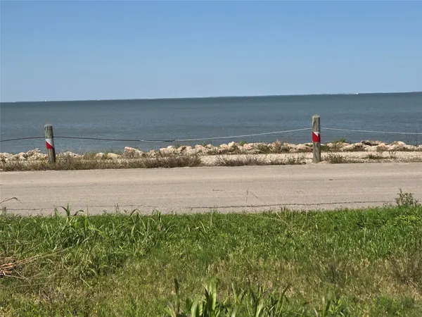 a view of a lake with a beach and a big yard