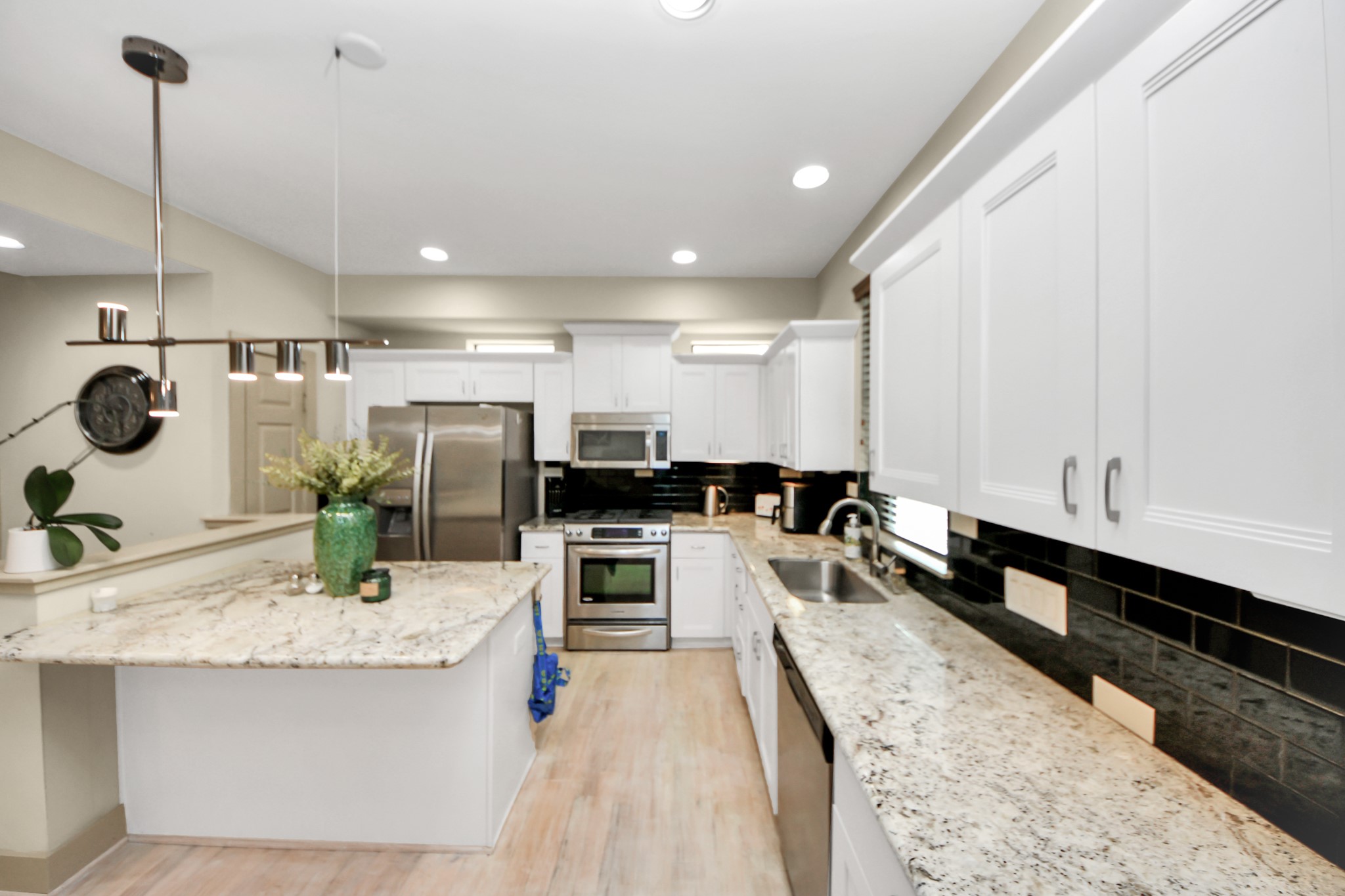 4510 Inker Street, Unit B Houston, TX 77007 - Photo 12 of 43 a kitchen with kitchen island granite countertop a sink a counter top space appliances and cabinets