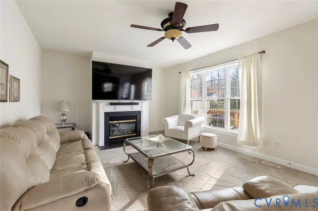 a living room with furniture a fireplace and a flat screen tv