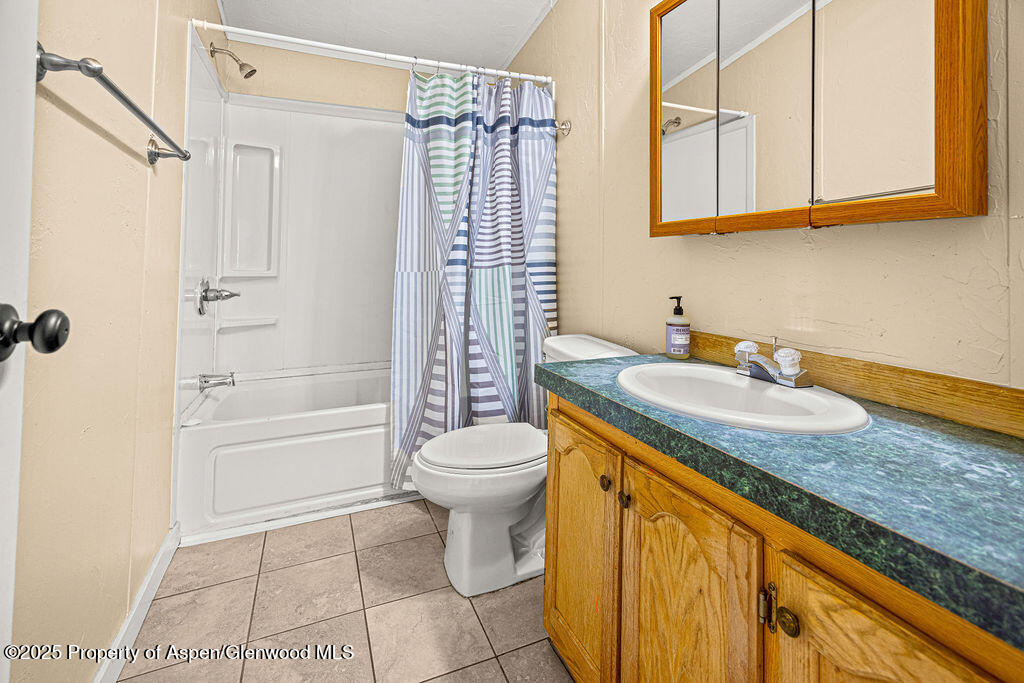 405 Hawthorn Street Craig, CO 81625 - Photo 23 of 35 a bathroom with a granite countertop sink a toilet mirror and bathtub