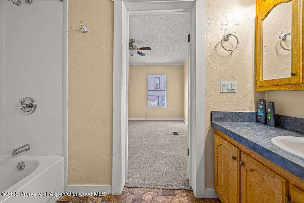 405 Hawthorn Street Craig, CO 81625 - Photo 24 of 35 a bathroom with a granite countertop sink vanity mirror and shower
