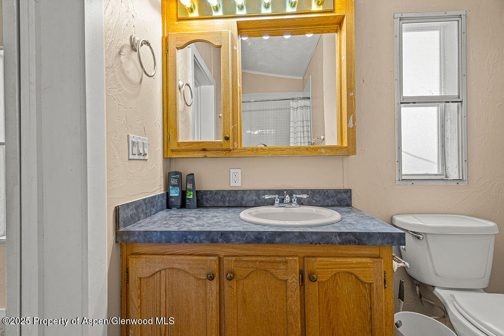 405 Hawthorn Street Craig, CO 81625 - Photo 25 of 35 a bathroom with a granite countertop toilet sink and mirror