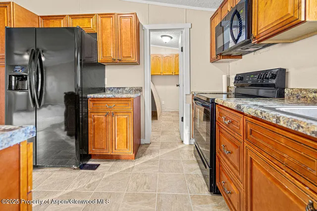 a kitchen with stainless steel appliances granite countertop a refrigerator a oven and a sink
