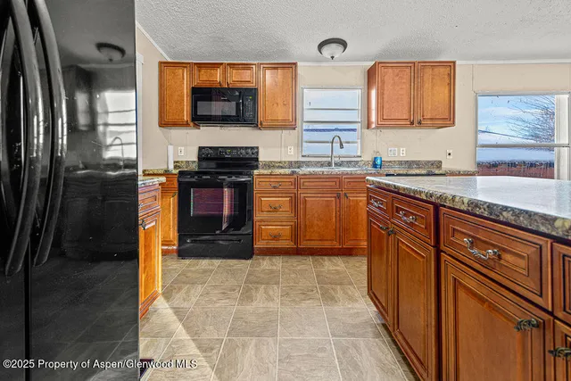 a kitchen with stainless steel appliances granite countertop a stove top oven a sink and dishwasher