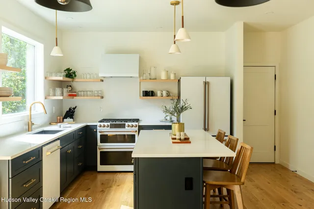 a kitchen with a sink a stove and chairs