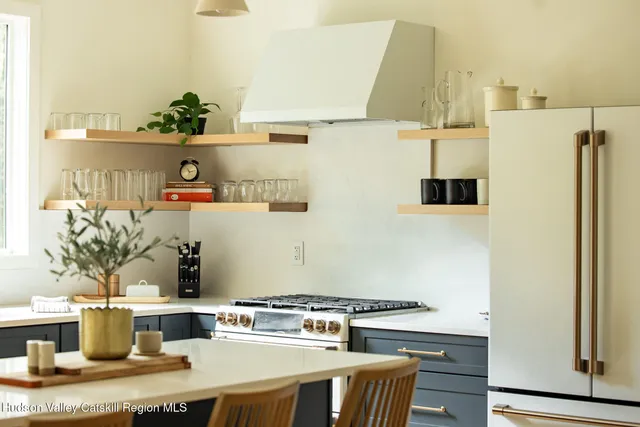 a room with stainless steel appliances kitchen island granite countertop a table and a stove