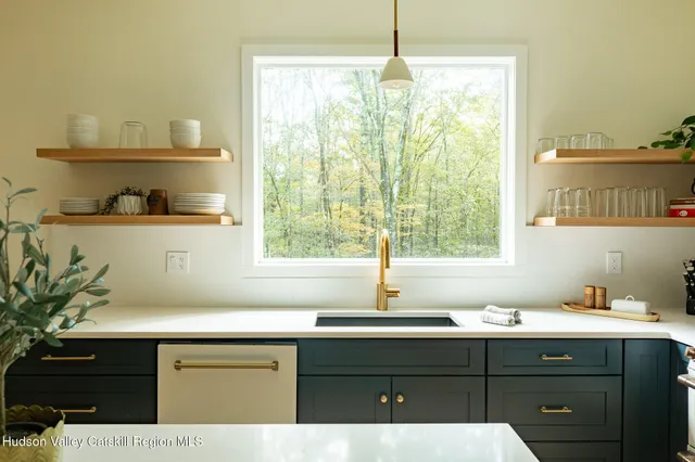 a sink with a window and cabinets