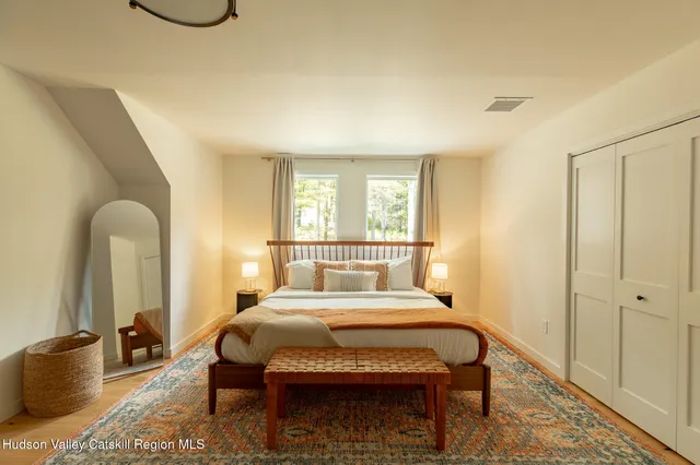 a bedroom with a bed a table and painting on the wall