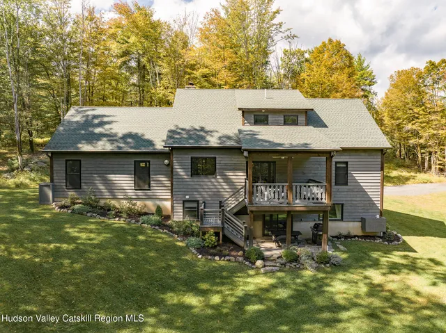 a view of house with yard and sitting area
