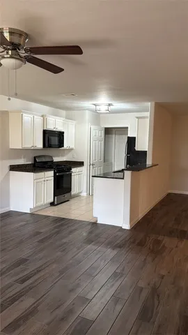 a view of a kitchen with a sink microwave and cabinets