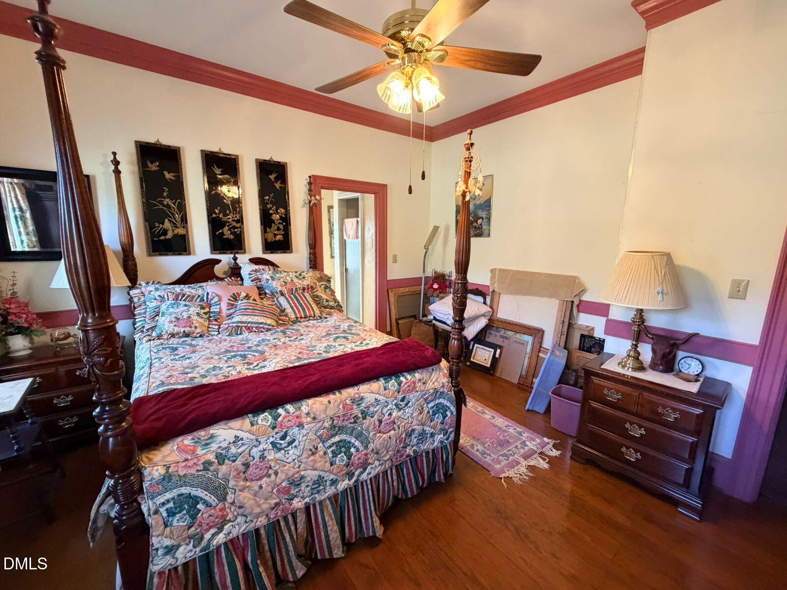 9222 Midway Road Bailey, NC 27807 - Photo 16 of 35 a bedroom with a bed a flat screen tv and a chandelier
