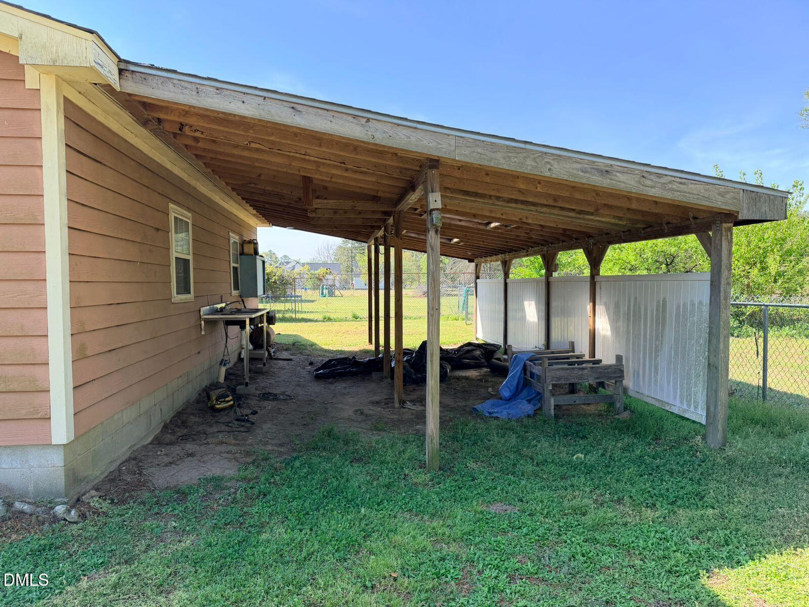 9222 Midway Road Bailey, NC 27807 - Photo 28 of 35 a view of a backyard with table and chairs under an umbrella with a small yard