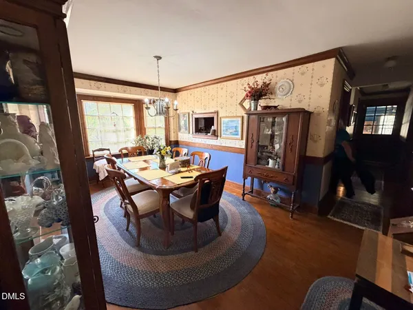 a dining room with furniture window and wooden floor