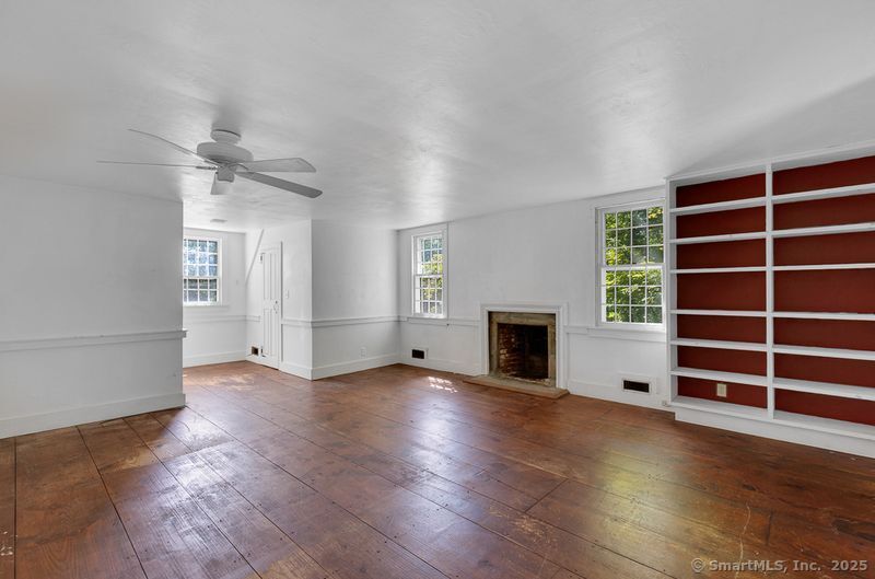 208 Woodcreek Road Bethlehem, CT 06751 - Photo 14 of 29 an empty room with wooden floor fireplace and windows