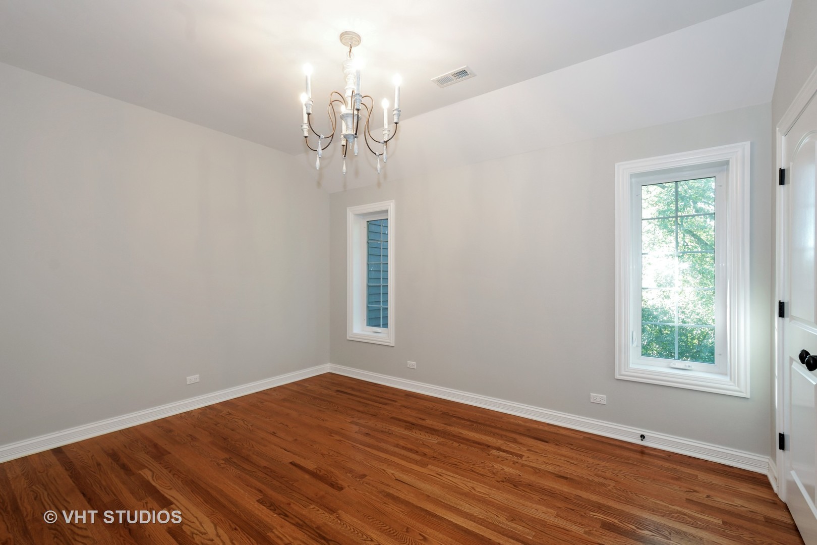1021 Linden Lane Glenview, IL 60025 - Photo 16 of 26 an empty room with wooden floor chandelier and windows