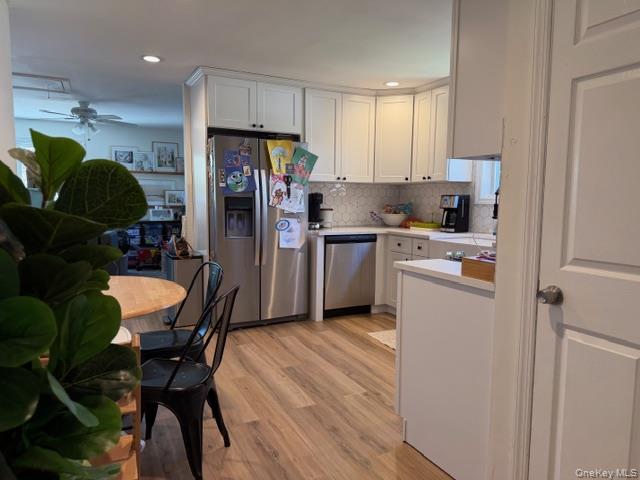 10 Hollingsworth Place Centereach, NY 11720 - Photo 8 of 19 a kitchen with stainless steel appliances kitchen island granite countertop a refrigerator a stove a sink a dining table and chairs with wooden floor