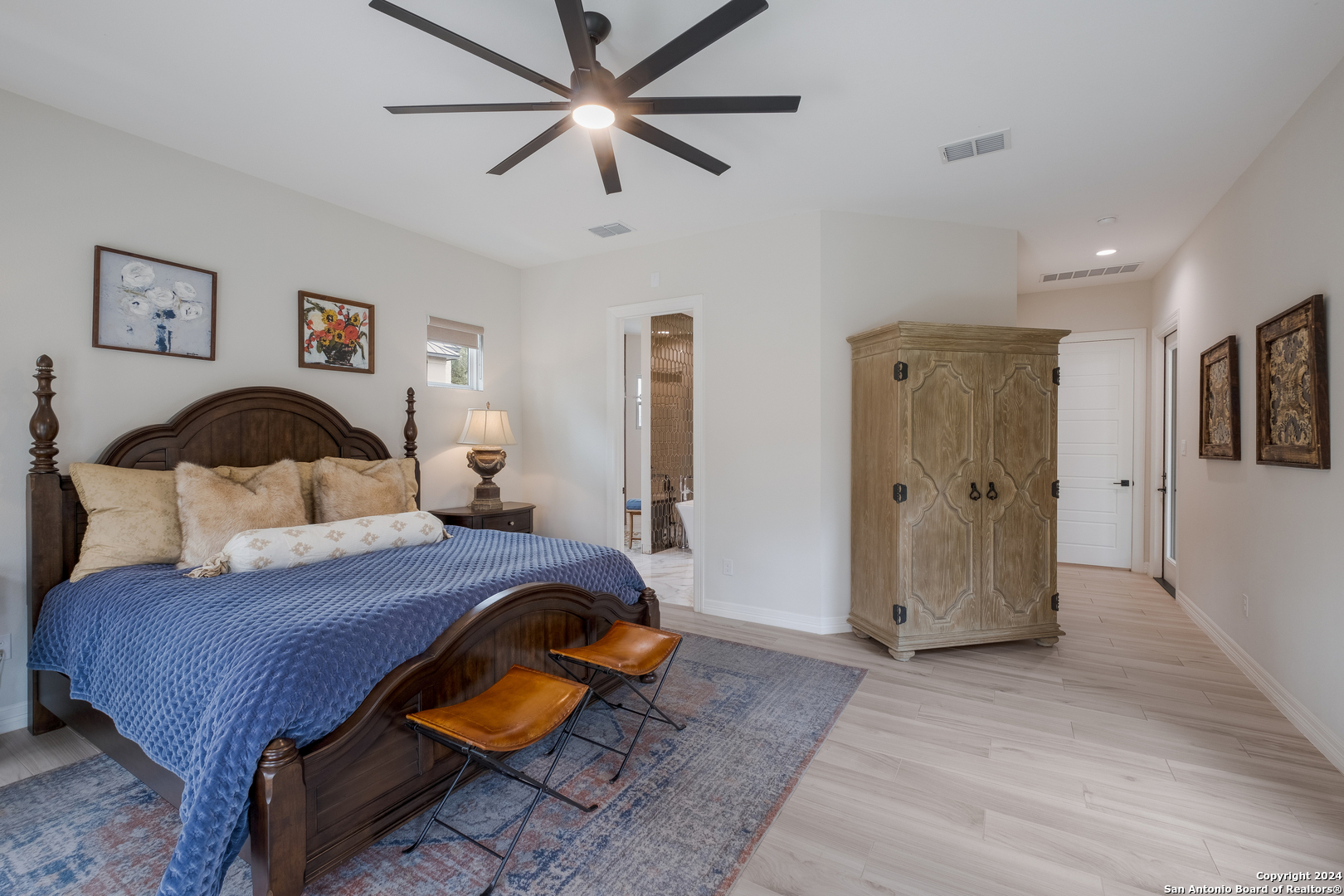 718 Post Oak Ridge Way Bulverde, TX 78163 - Photo 12 of 60 a bedroom with a bed and wooden floor
