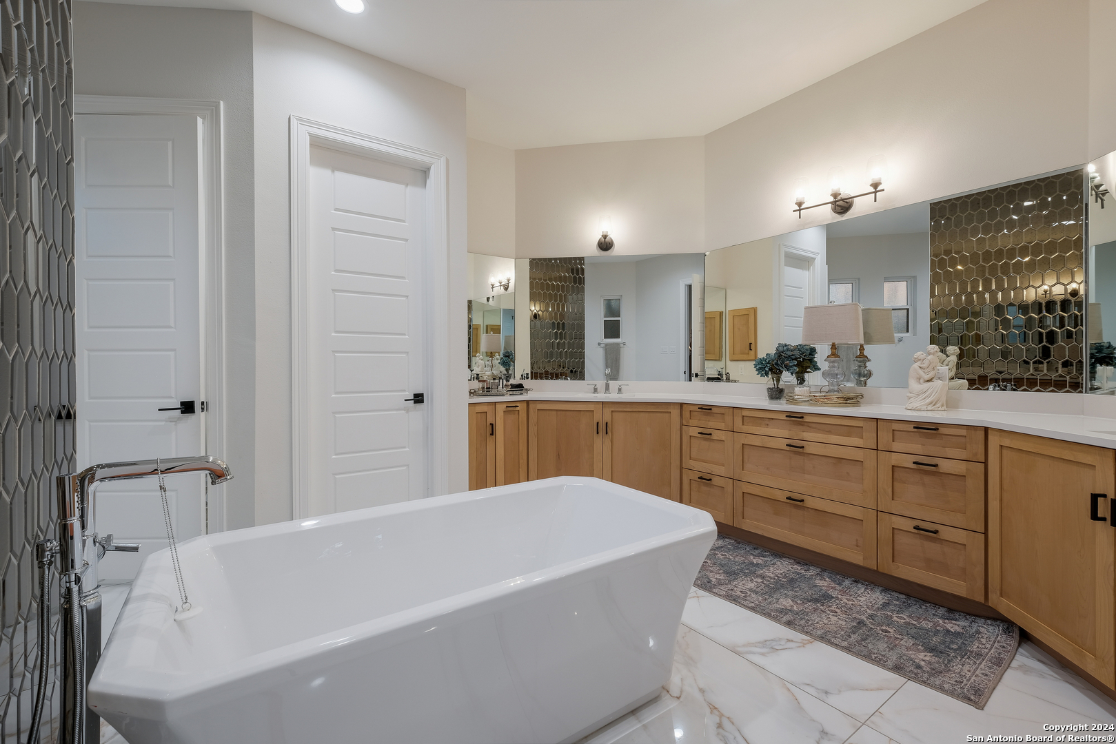 718 Post Oak Ridge Way Bulverde, TX 78163 - Photo 17 of 60 a bathroom with a tub a sink double vanity and a mirror