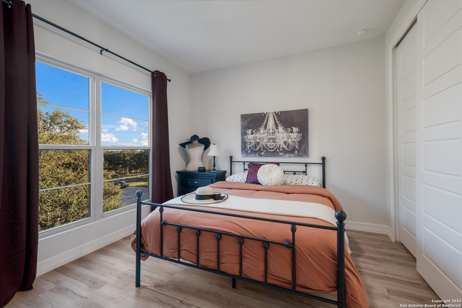 718 Post Oak Ridge Way Bulverde, TX 78163 - Photo 23 of 60 a bedroom with a bed a painting and a lamp on table