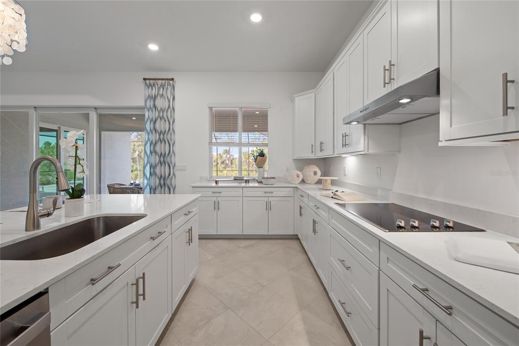 7161 Inlet Isles Lakewood Ranch, FL 34202 - Photo 11 of 29 a large white kitchen with granite countertop a sink a window stainless steel appliances and cabinets